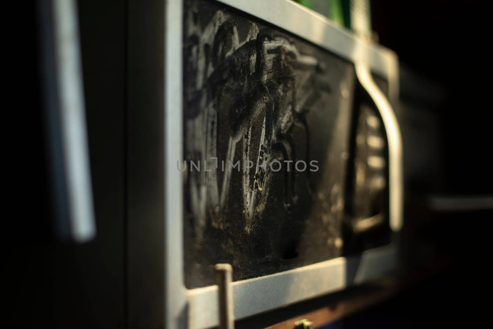 Old microwave oven in dust. Equipment in kitchen. Microwave oven with black glass. by OlegKopyov