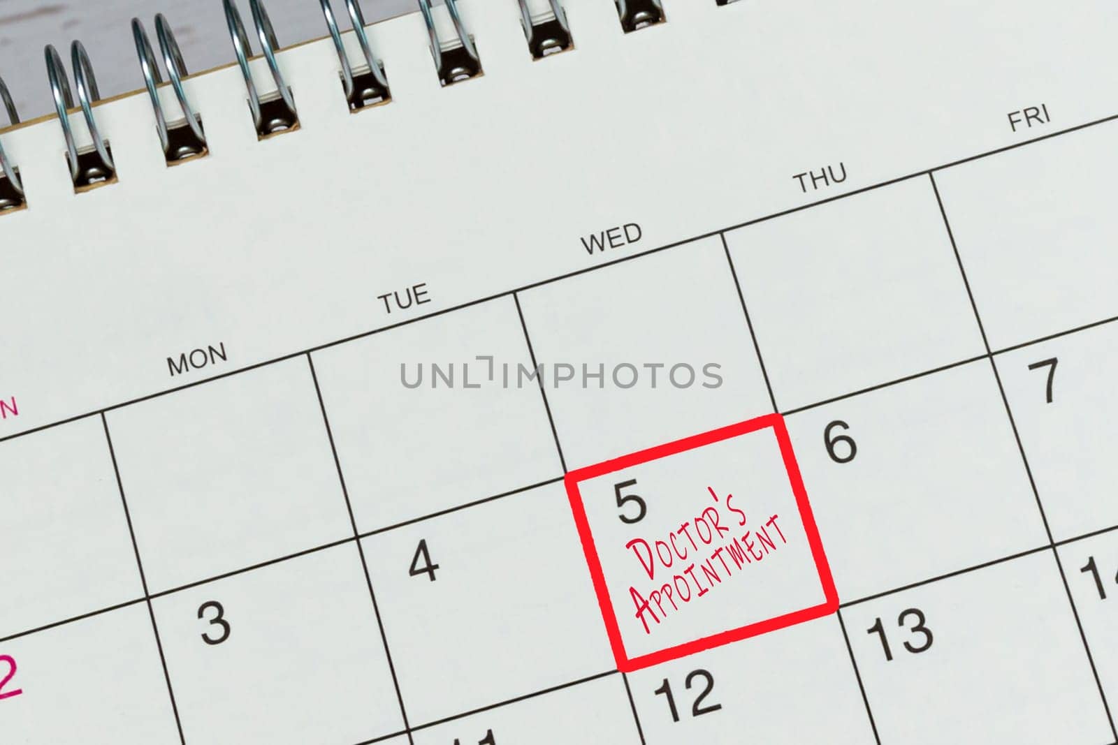 Red mark on the calendar at 5 for reminder of doctor's appointment. Health concept.