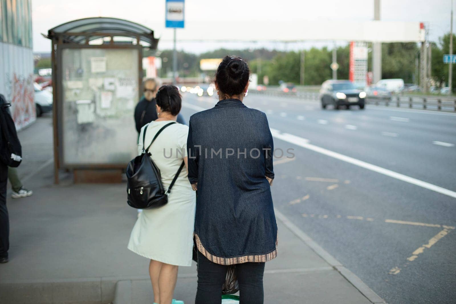 People are waiting for bus. Waiting for transport at bus stop. People in city.