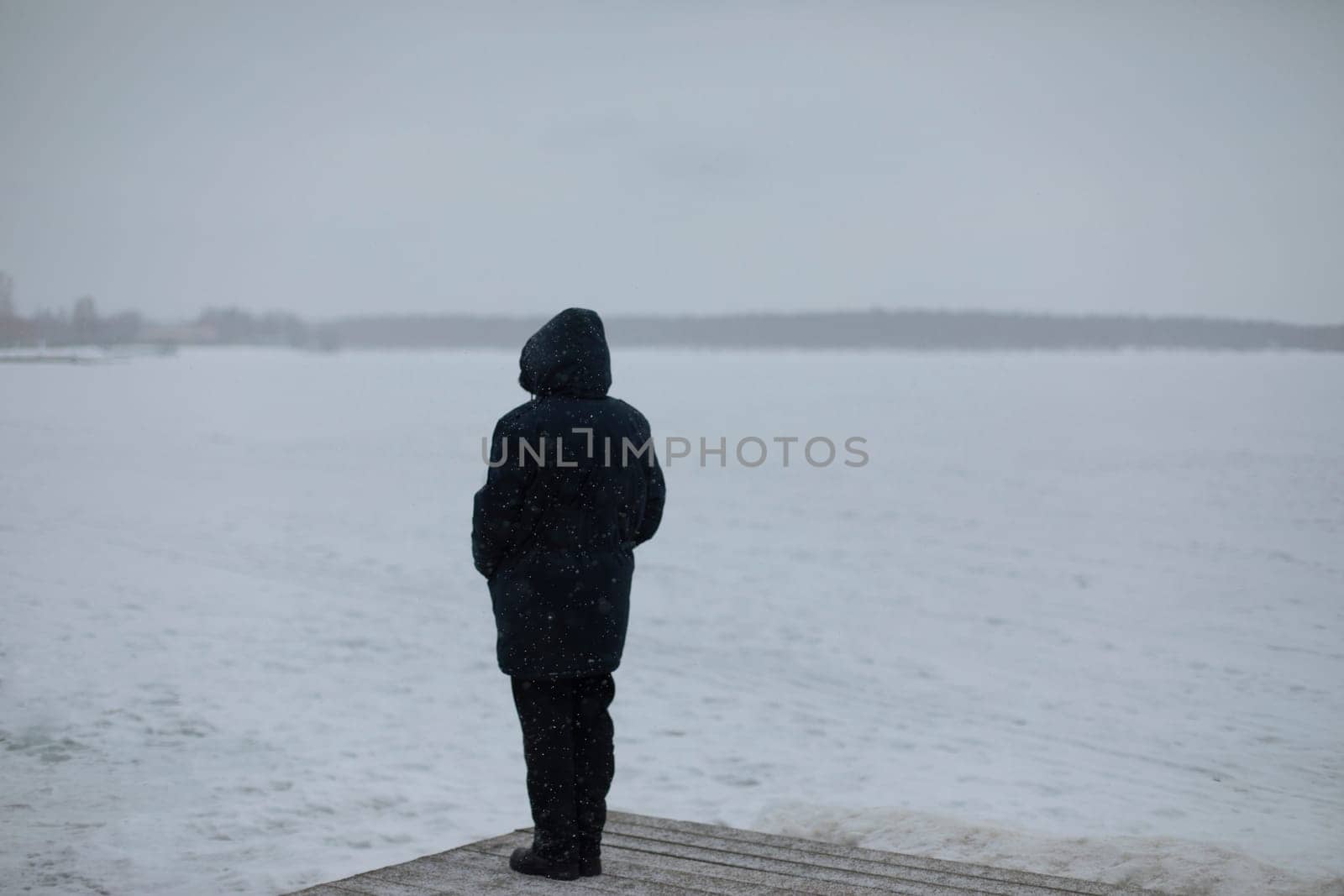 Man looks at snow lake. Woman in jacket. Girl looks at winter landscape.