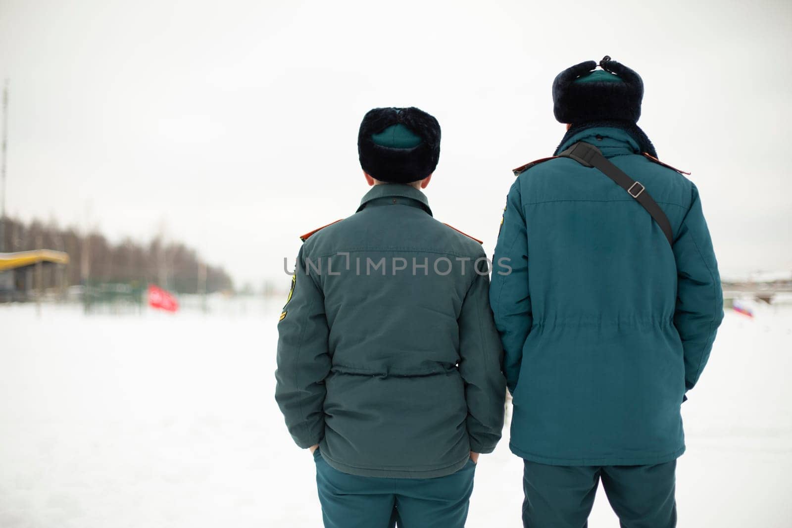 Two rescue workers. Men in uniform. Warm lifeguard uniform in Russia. by OlegKopyov