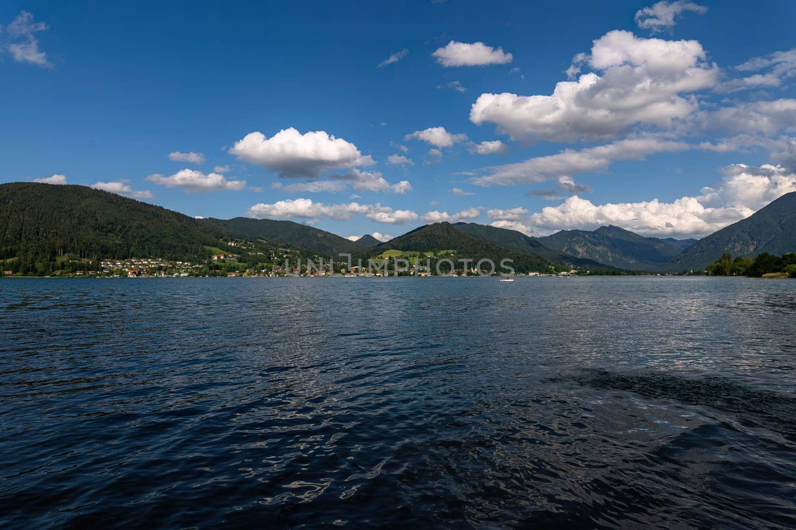 Expansive Alpine Lake View under Fluffy Clouds.