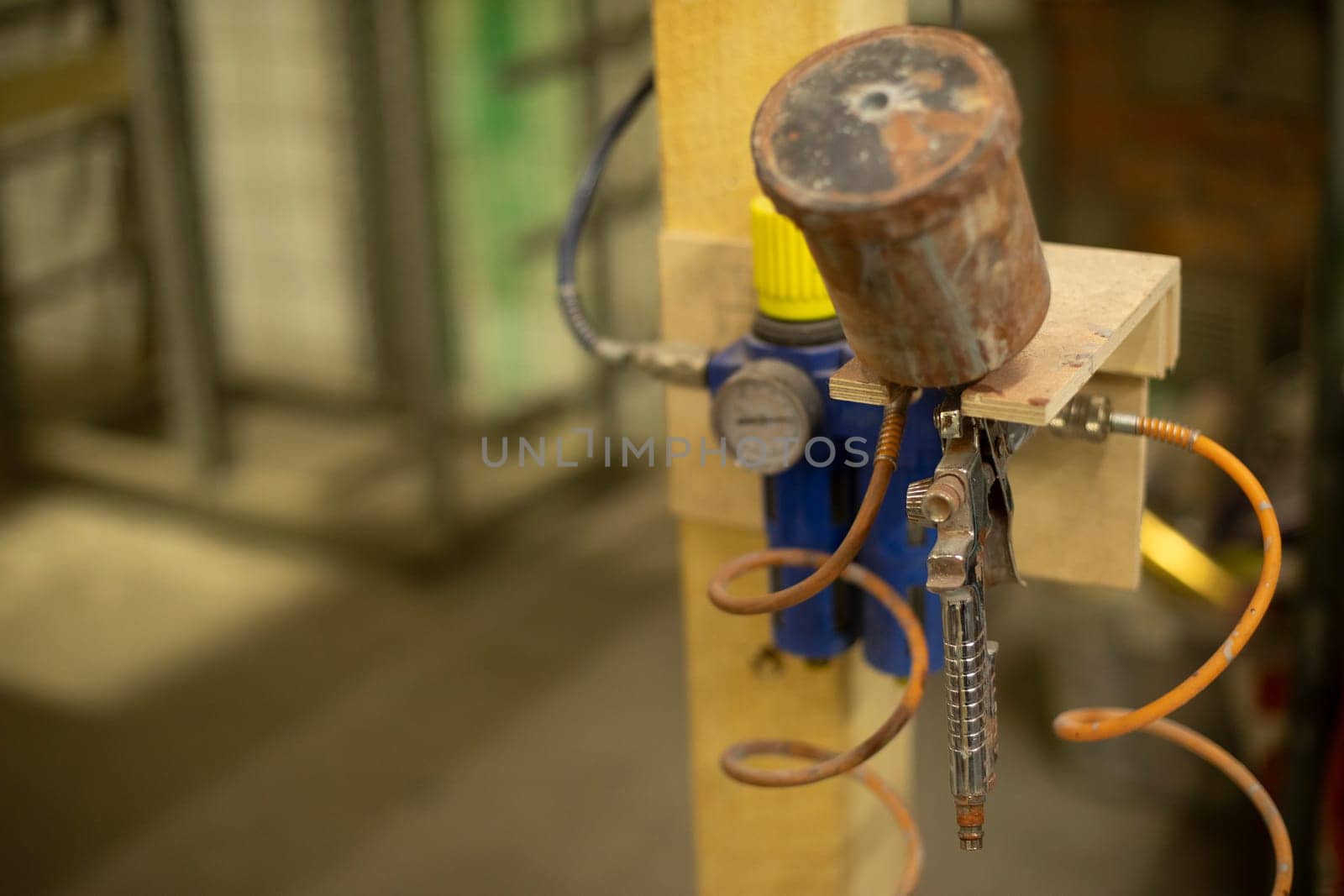 Pressure measuring device. Paint sprayer hangs on pole. Details of workshop. Technological subject.