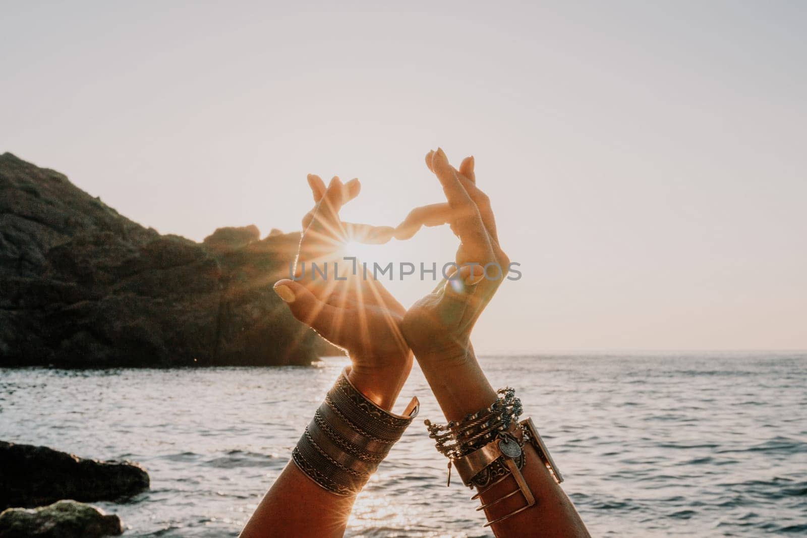 Woman sea yoga. Happy woman in white swimsuit and boho style braclets practicing outdoors on yoga mat by sea on sunset. Women yoga fitness routine. Healthy lifestyle, harmony and meditation by panophotograph