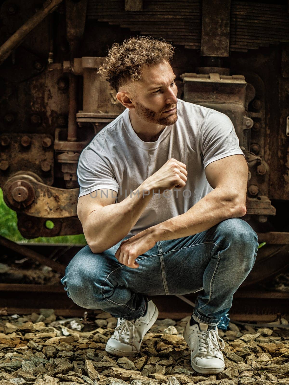 A man sitting on a train track next to a train