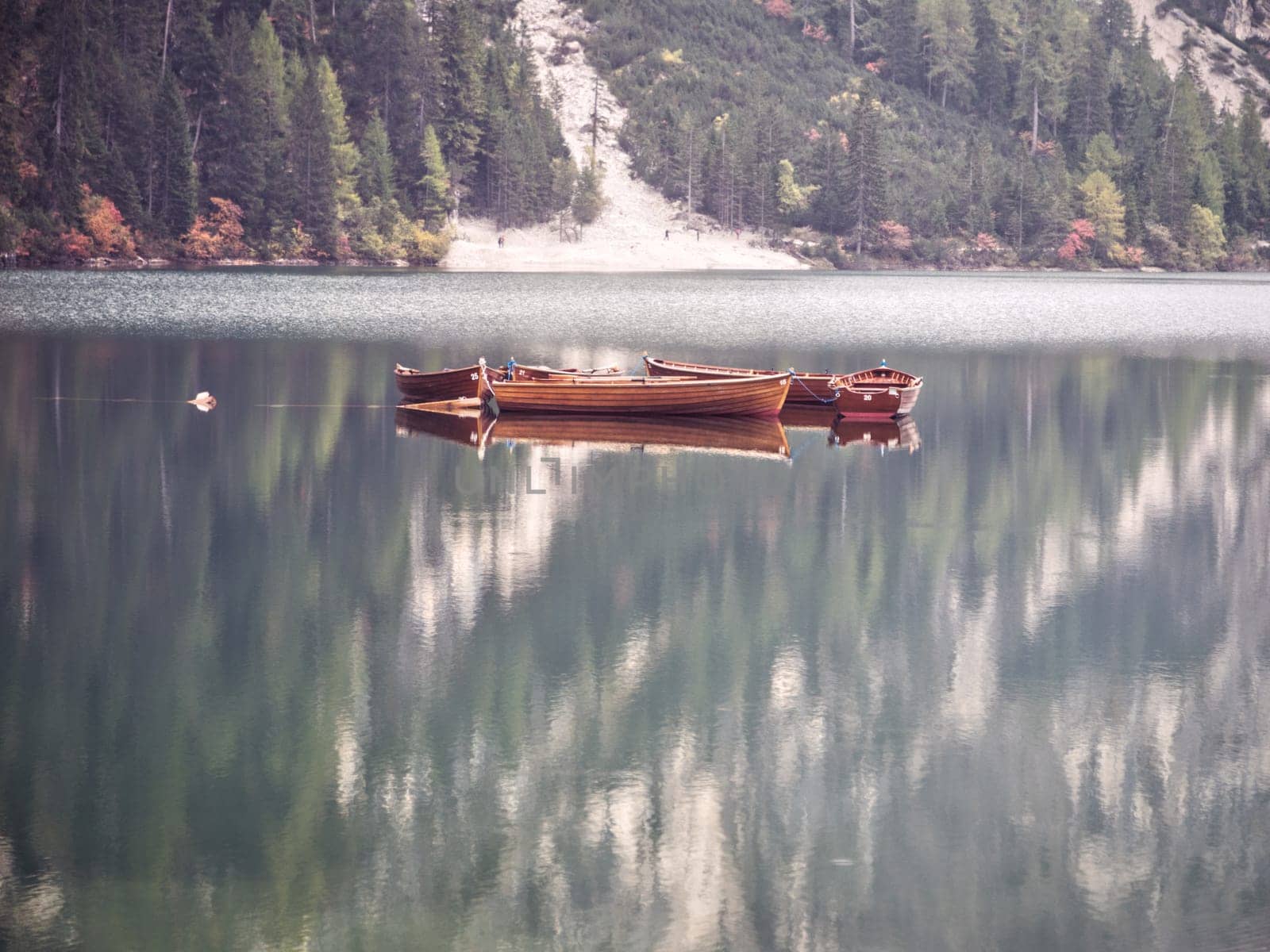 Photo of a serene boat floating on a picturesque lake with a majestic mountain backdrop by artofphoto