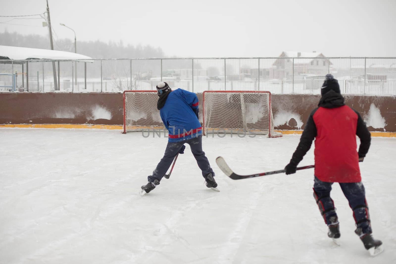 Playing hockey. Guys skate. Hockey player with stick. Ice skating. by OlegKopyov