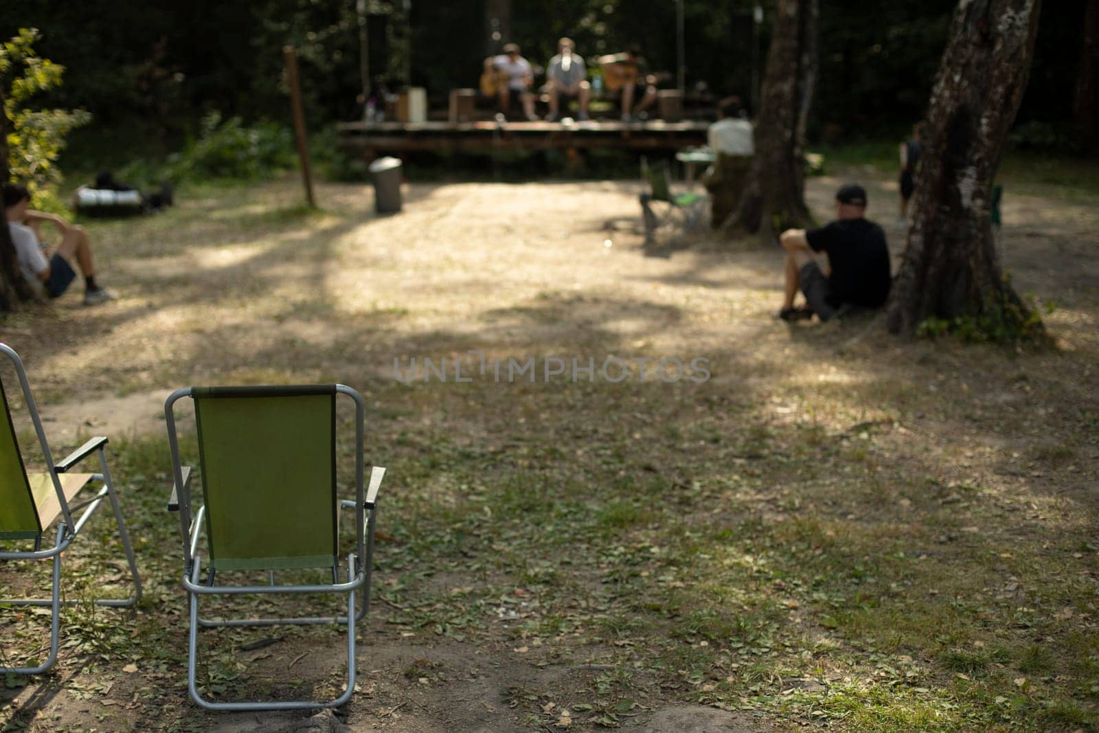 Chair at festival. Rest in woods. People in nature. Concert in park. Tourist chair stands on ground.