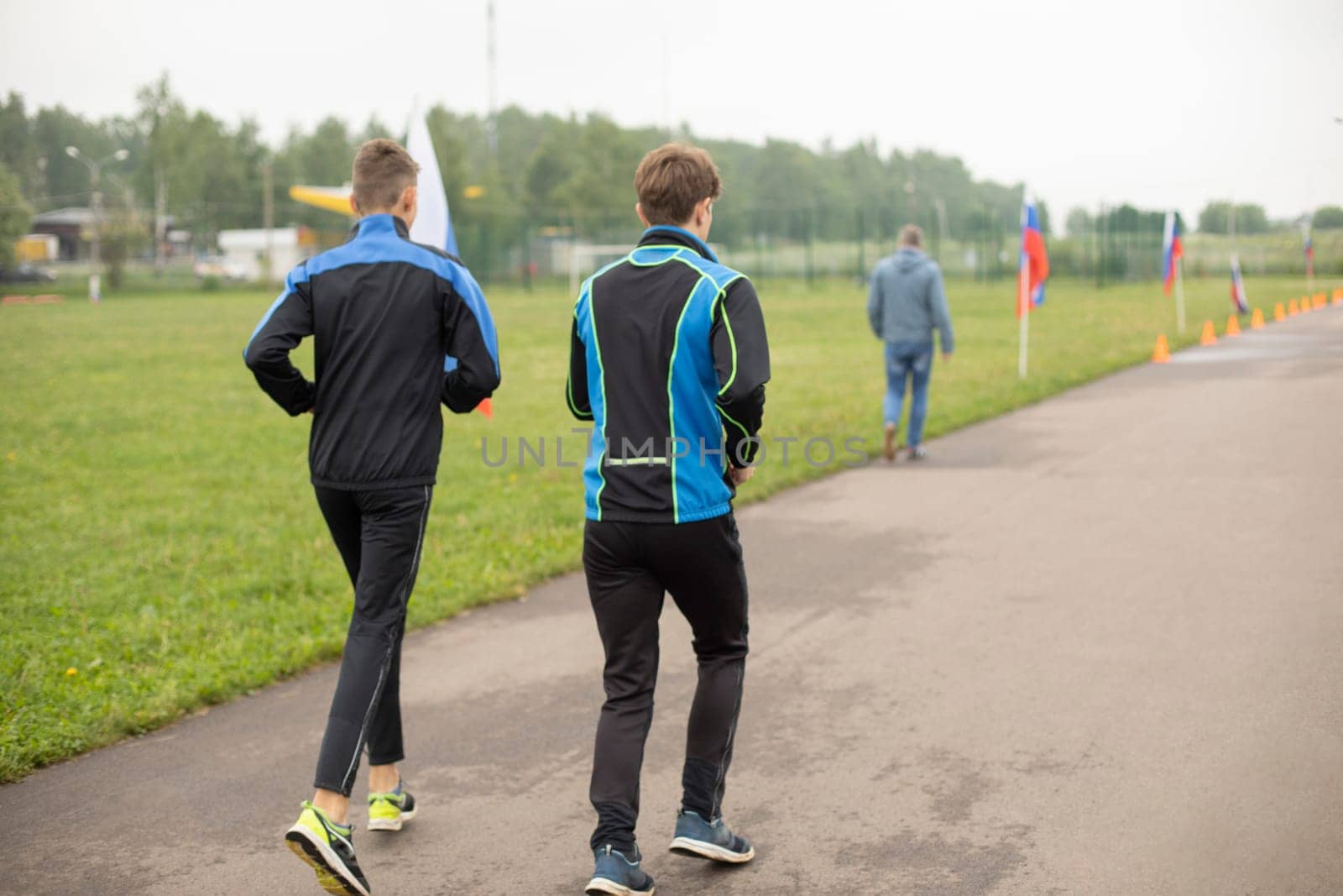 Jogging in park. Students run in stadium. by OlegKopyov
