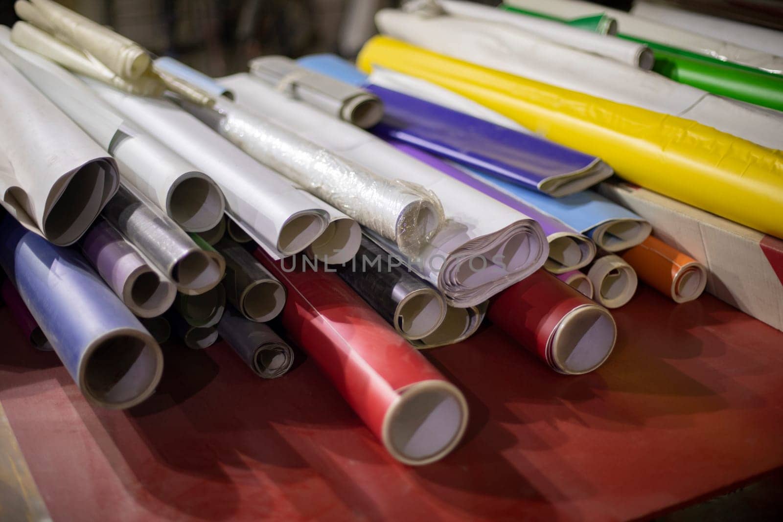 Film with glue. Rolls of paper of different colors. Advertising material. Lots of rolls with adhesive film.