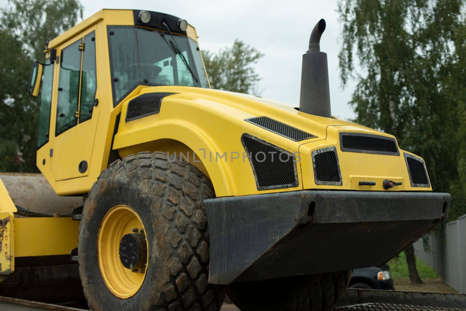 Transportation on platform of heavy machinery. Yellow tractor. Construction machinery on transport.