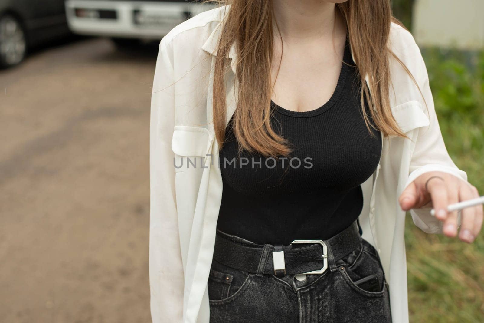 Girl in black T-shirt and white shirt. Teenager on street. Woman breast. Smoking schoolgirl. by OlegKopyov