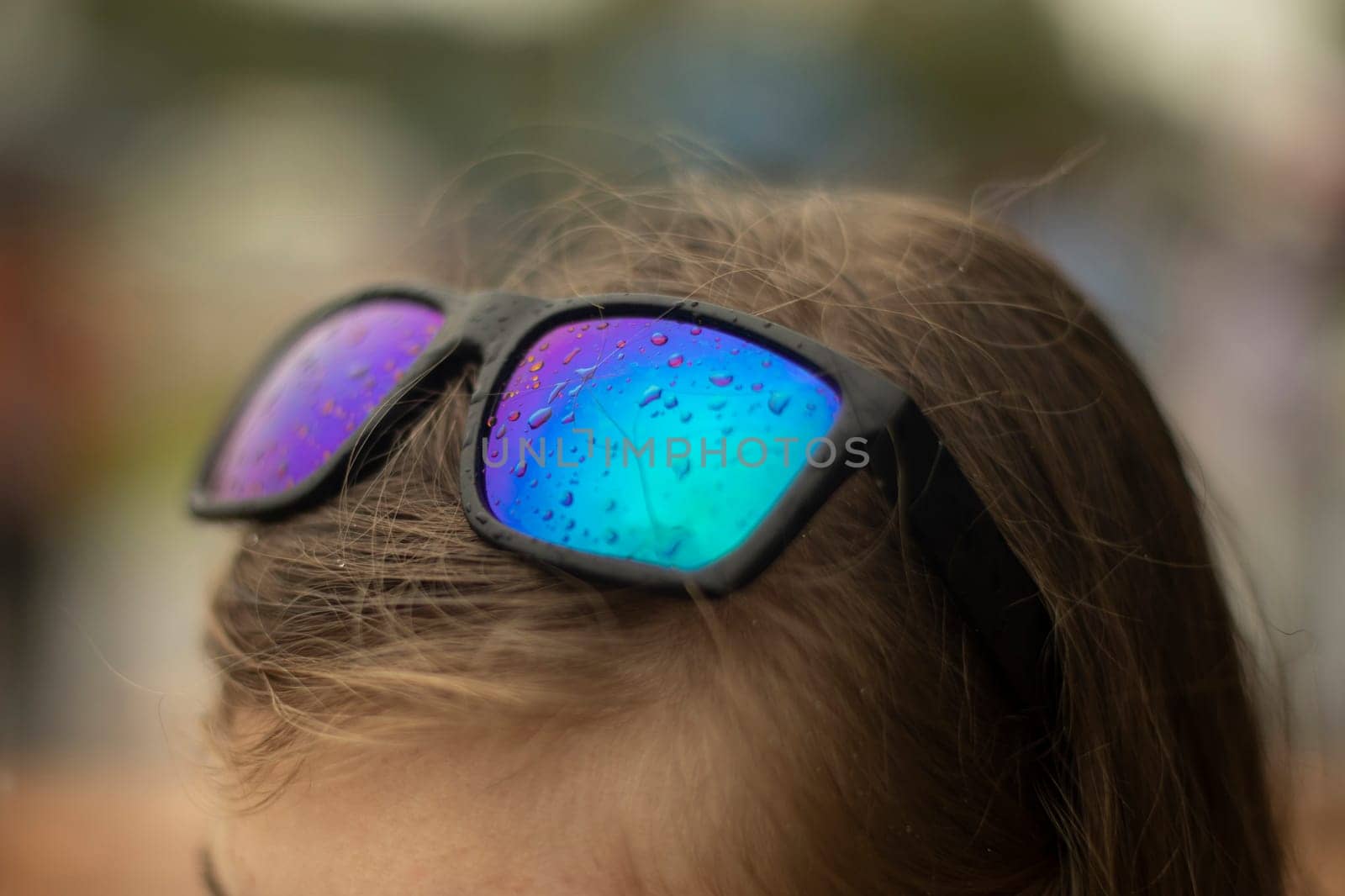 Glasses with raindrops. Glasses on head. Blue glass. Wet glass. Girl's head. Fashion accessory.
