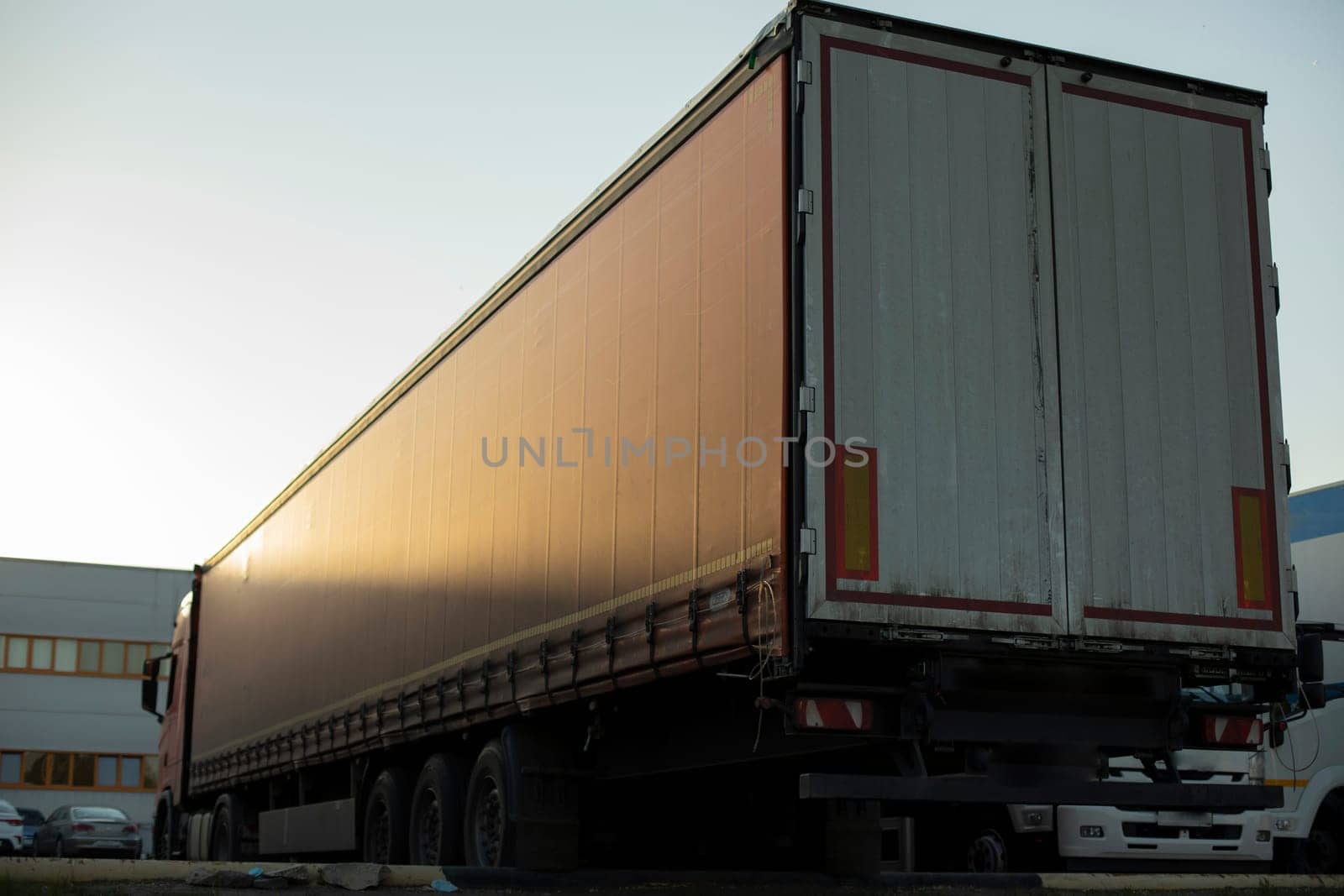 Truck is parked in parking lot. Trucks parked in city. Awning on large trailer. by OlegKopyov
