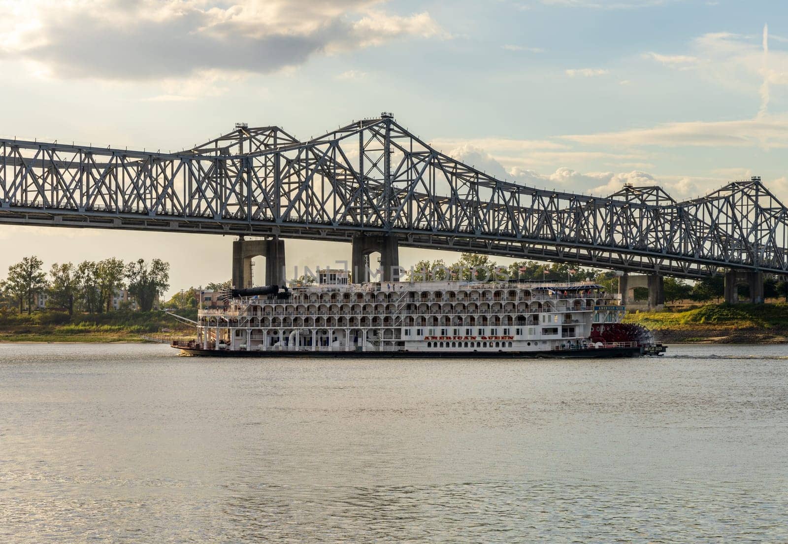 Natchez, MS - 26 October 2023: Paddle steamer river cruise boat American Queen departs under interstate bridge from Natchez Mississippi
