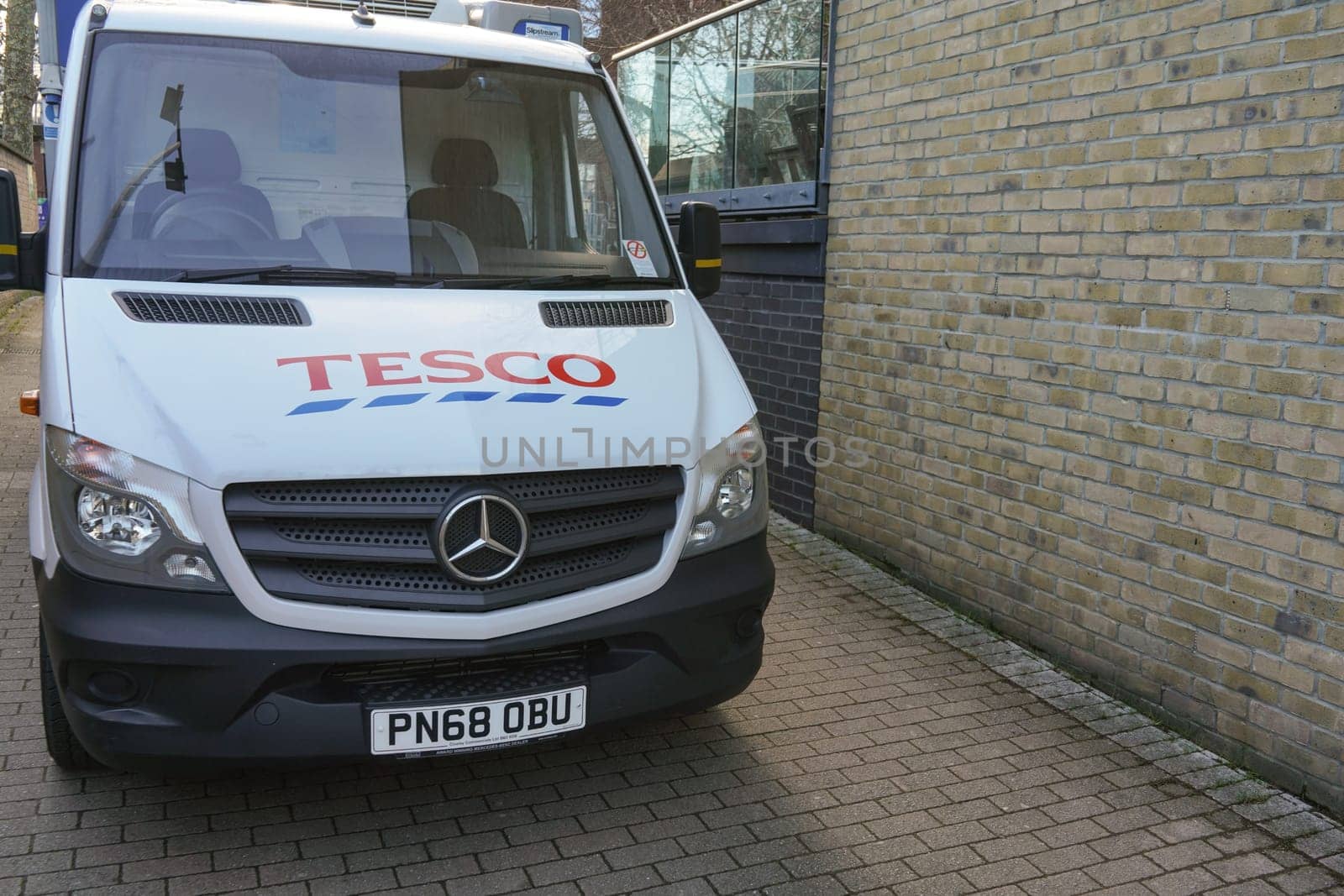 London, United Kingdom - February 03, 2019: White Tesco delivery van parked in small street, British supermarket offers food and groceries deliveries to home address anywhere in UK. by Ivanko