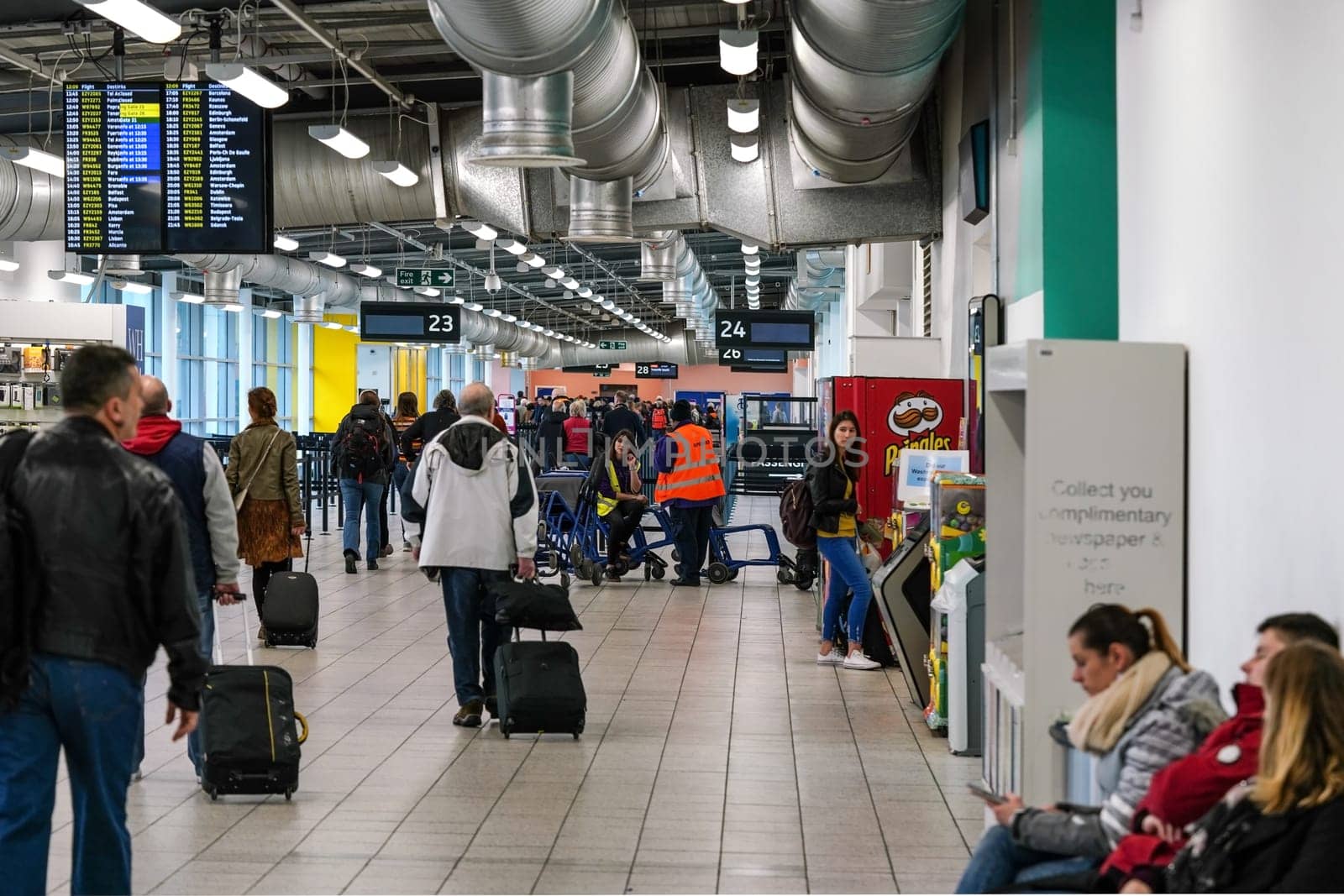 London, United Kingdom - February 05, 2019: Passengers walking to boarding gate, some waiting seated, at Luton airport. LTN is UK fifth busiest with 16.5 million passengers transported in 2018 by Ivanko