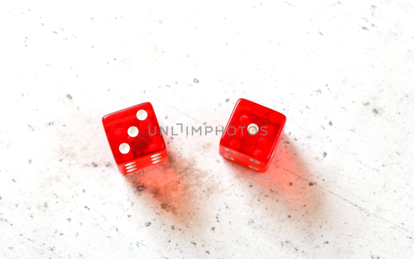 Two red craps dices showing Easy Four (number 3 and 1) overhead shot on white board