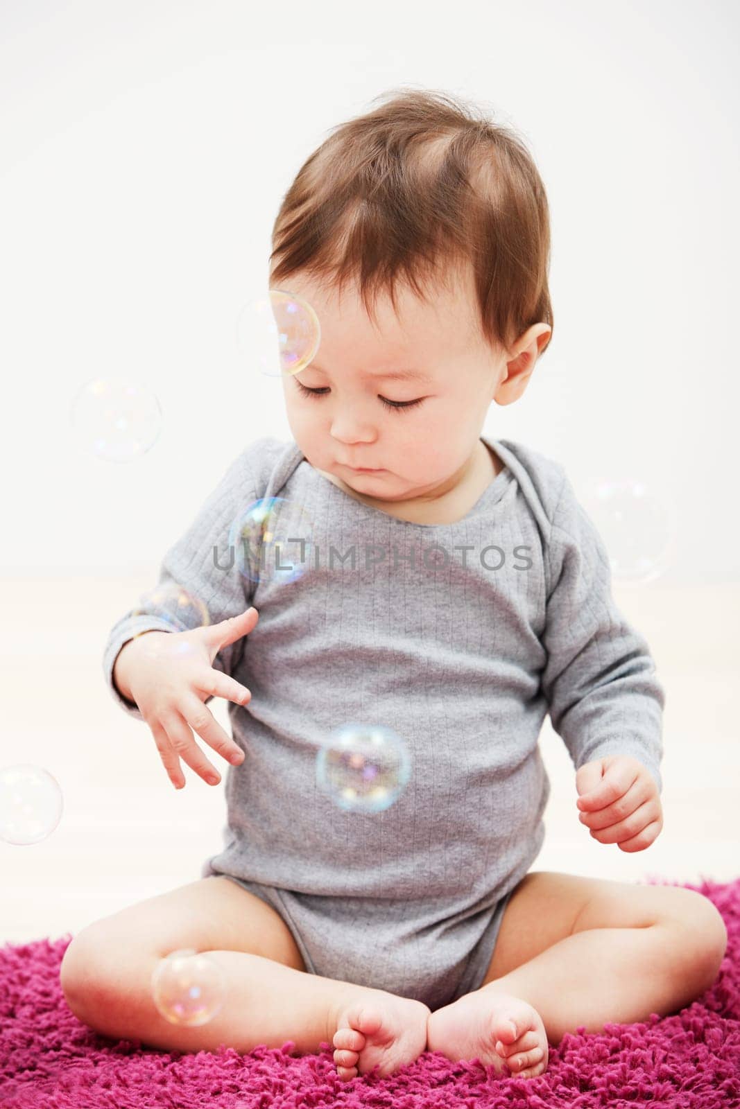 Baby, bubbles and playing game in home for childhood development, curious wondering or education. Kid, growth toys and mockup space or learning progress for sensory, coordination or entertainment.