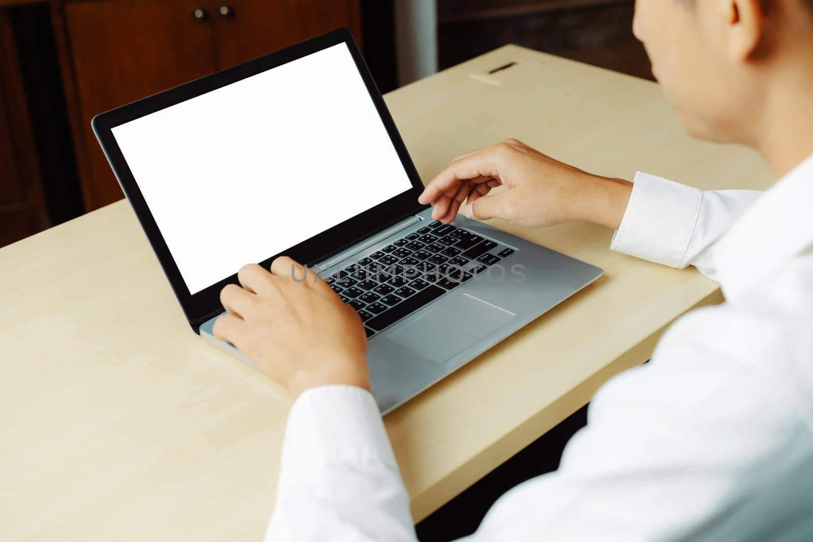 Business person or office worker using laptop computer while sitting at desk. uds