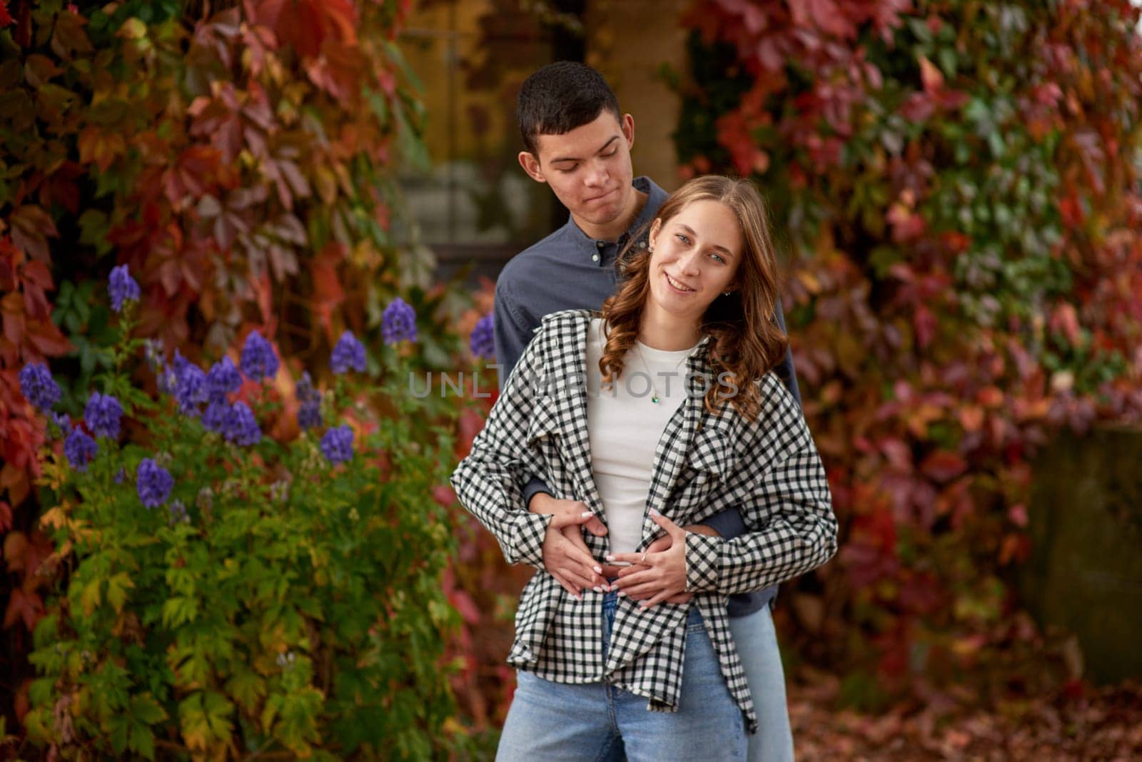 Young Cute Female Hugs Boyfriend. In Autumn Outdoor. Lovers Walking in Park. Attractive Funny Couple. Lovestory in Forest. Man and Woman. Cute Lovers in the Park. Family Concept. Happy Couple.