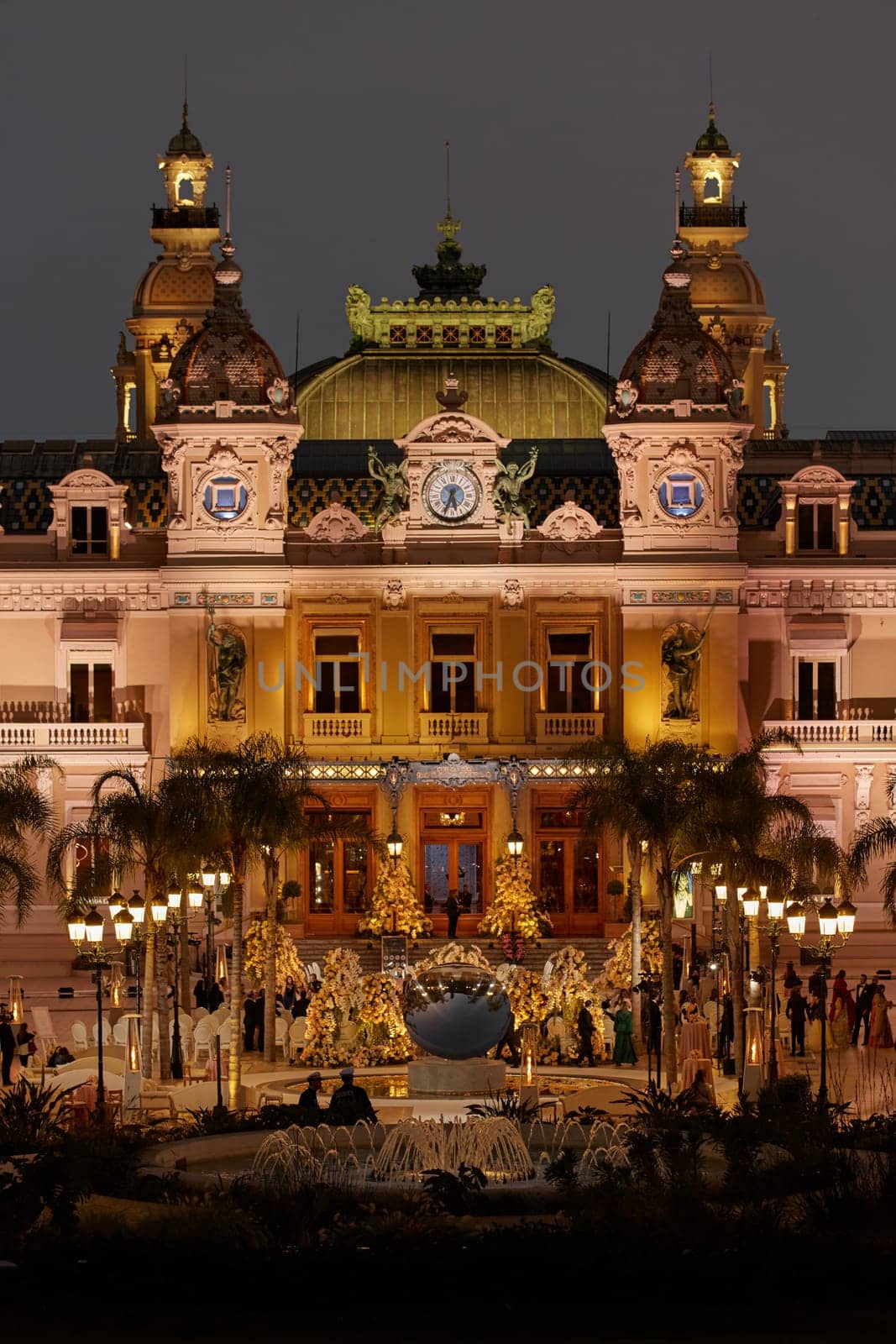 Monaco, Monte-Carlo, 12 November 2022: The famous square of Casino Monte-Carlo is at dusk, attraction night illumination, luxury cars, players, tourists, splashes of fountain. High quality photo