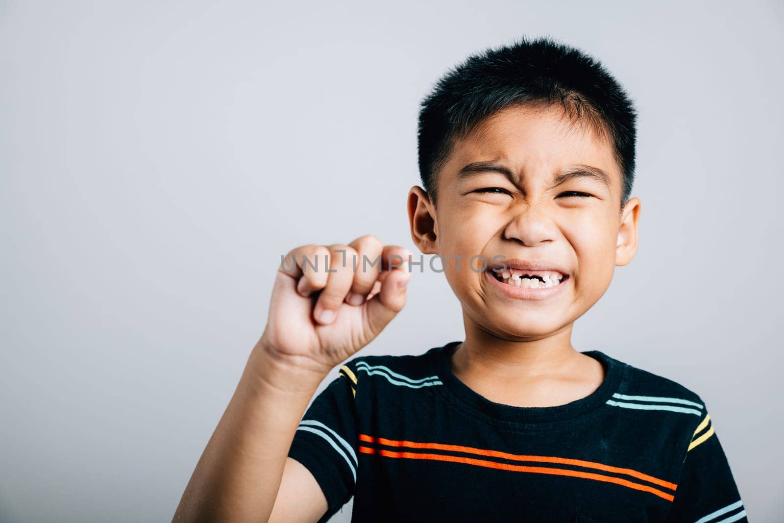 A little boy holds a fallen baby tooth signifying oral hygiene. First tooth lost embodies toddler development joy and growth. Children show teeth new gap, dentist problems