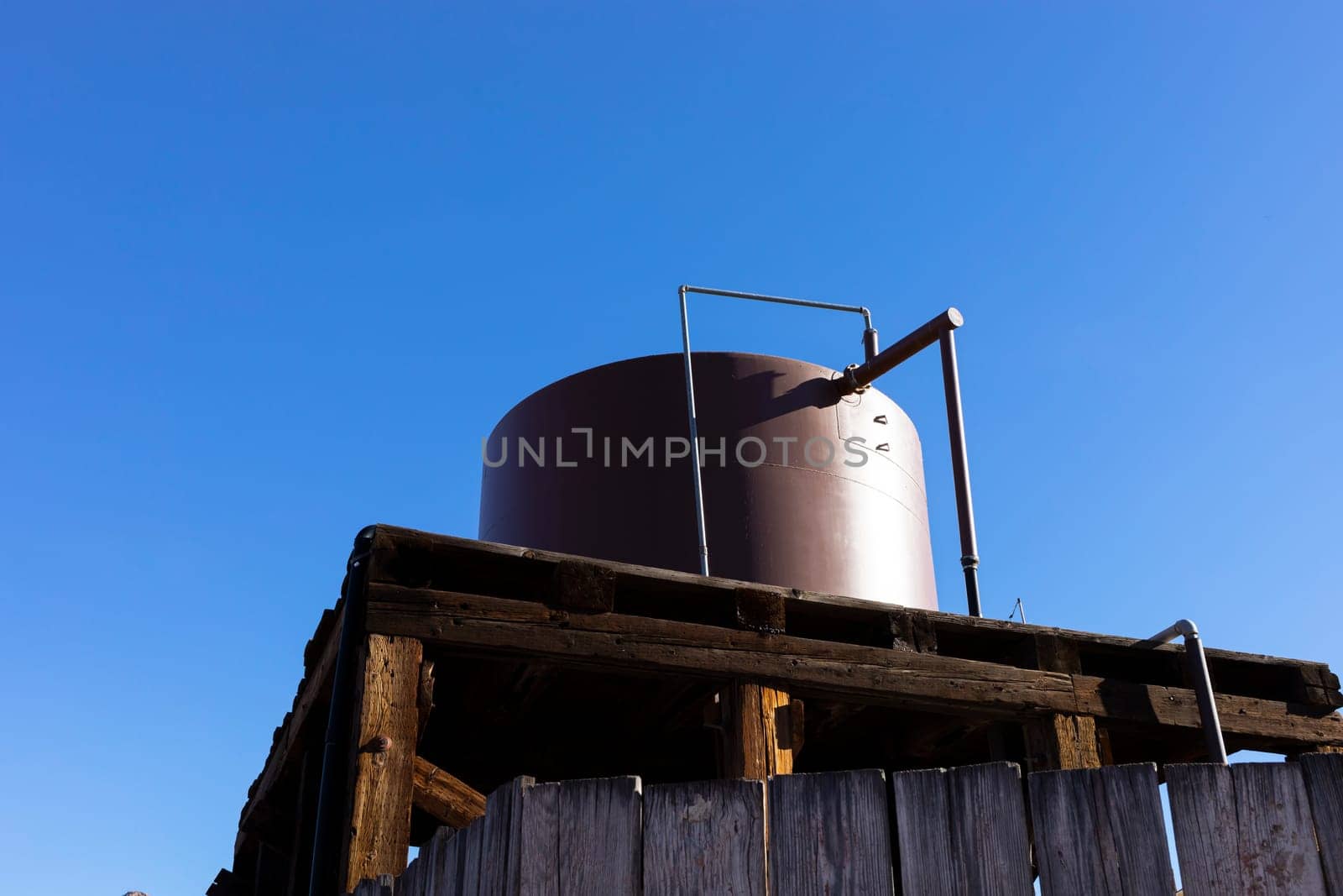 Water Tank, Barrel For Heating Under Sun On Workshop Building Outdoor at Countryside. Hot Water For Summer Cottage or Agriculture. Blue Sky on Background. Horizontal Plane. High quality photo