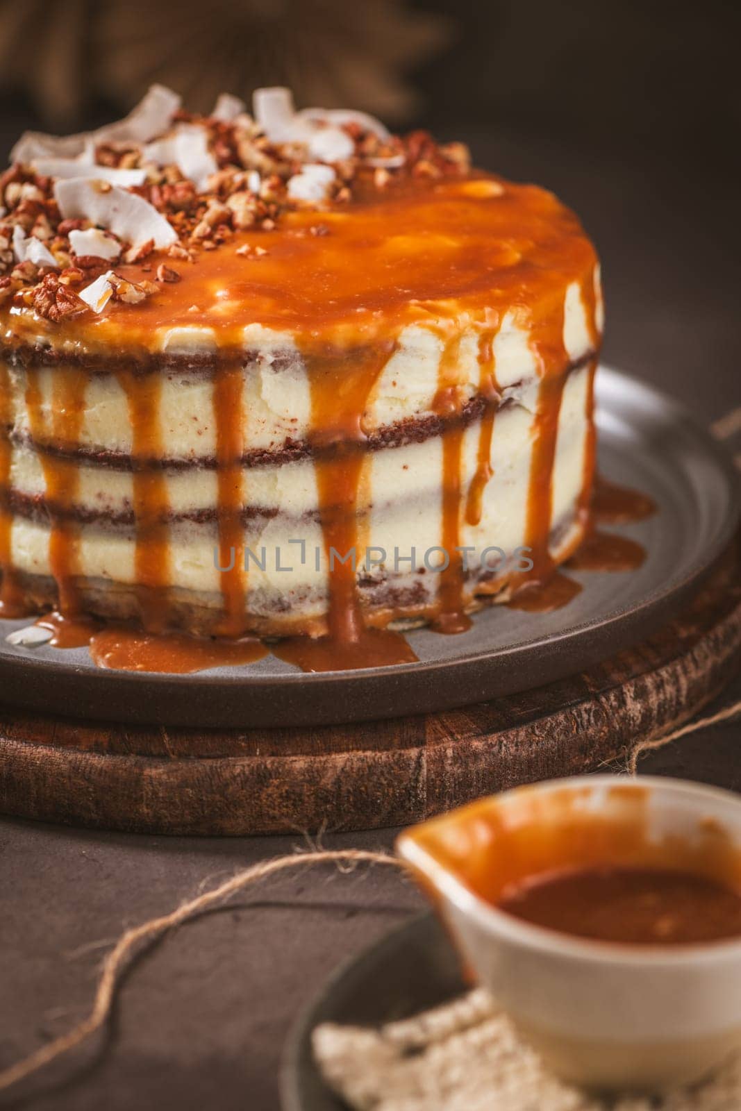 Delicious caramel cake with small pieces of pecan nuts and coconut shavings.