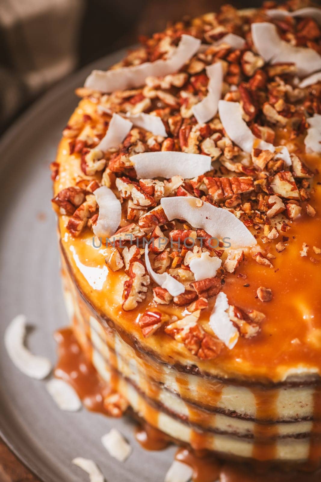 Delicious caramel cake with small pieces of pecan nuts and coconut shavings.