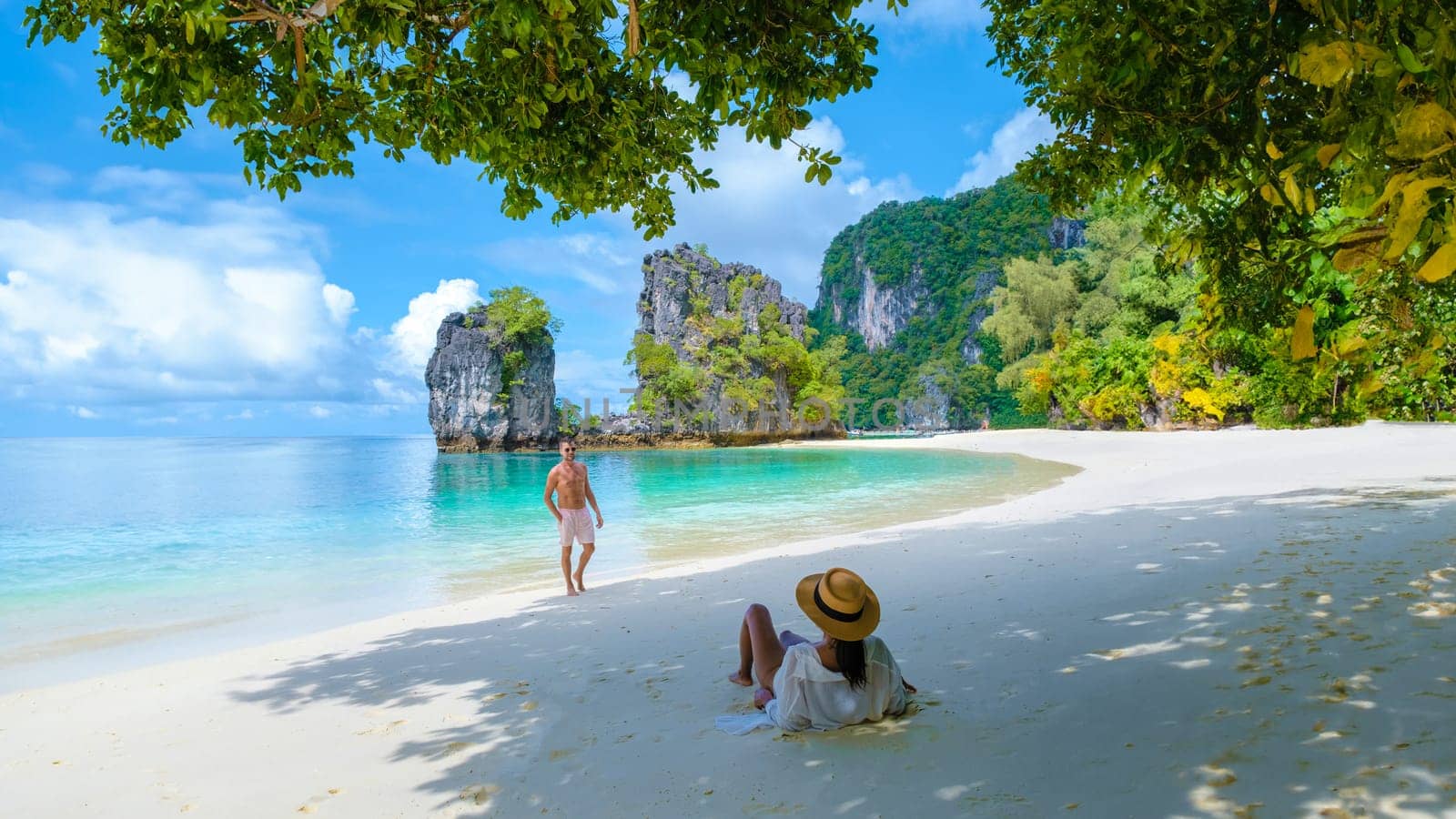 a couple of men and women on the beach of Koh Hong during vacation in Thailand, a tropical white beach with Asian women and European men in Krabi Thailand. Koh Hong Island Krabi Thailand,