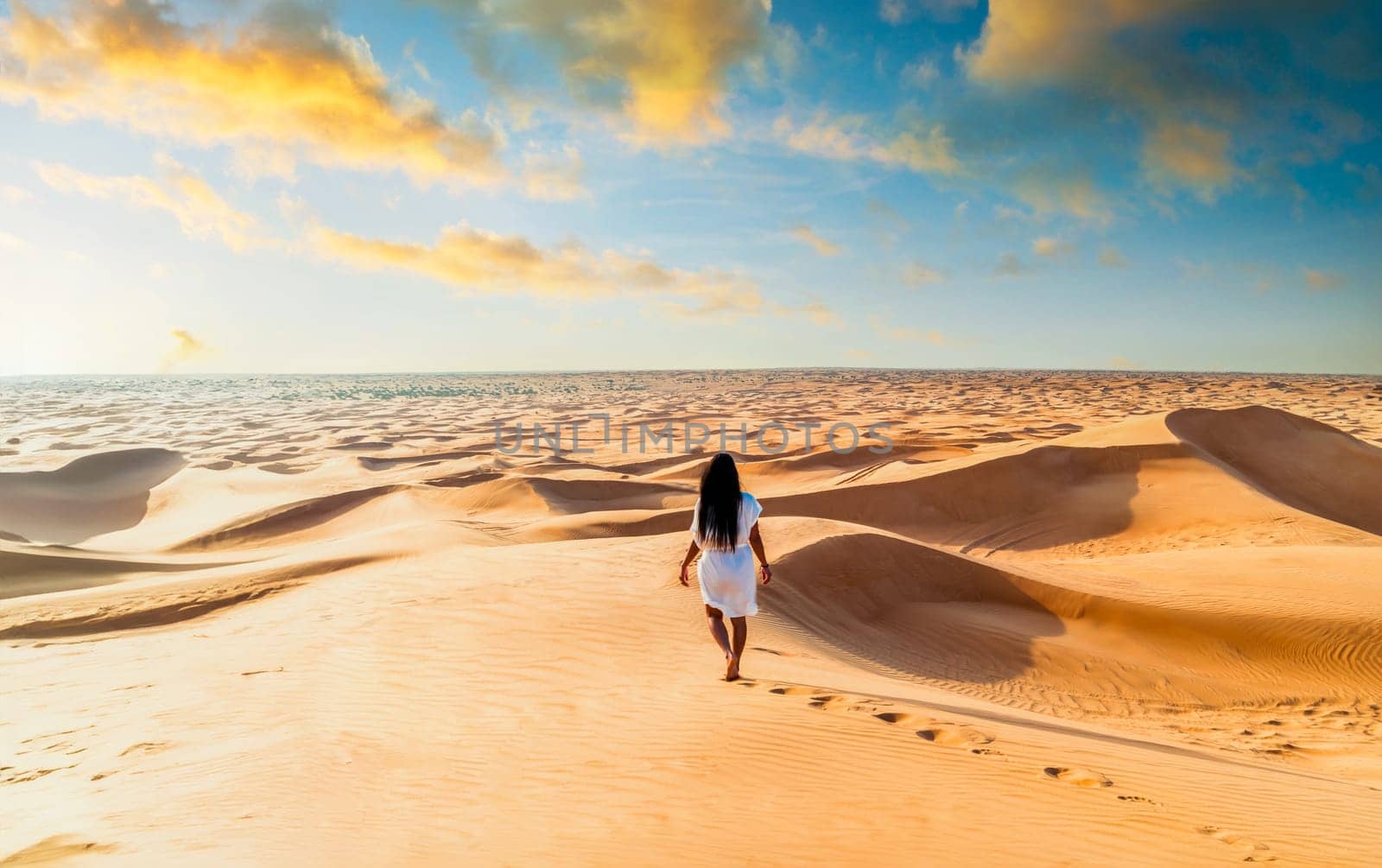 Dubai desert sand dunes, an Asian woman on Dubai desert safari, United Arab Emirates vacation, woman on vacation in Dubai walking at the sand dunes of Dubai