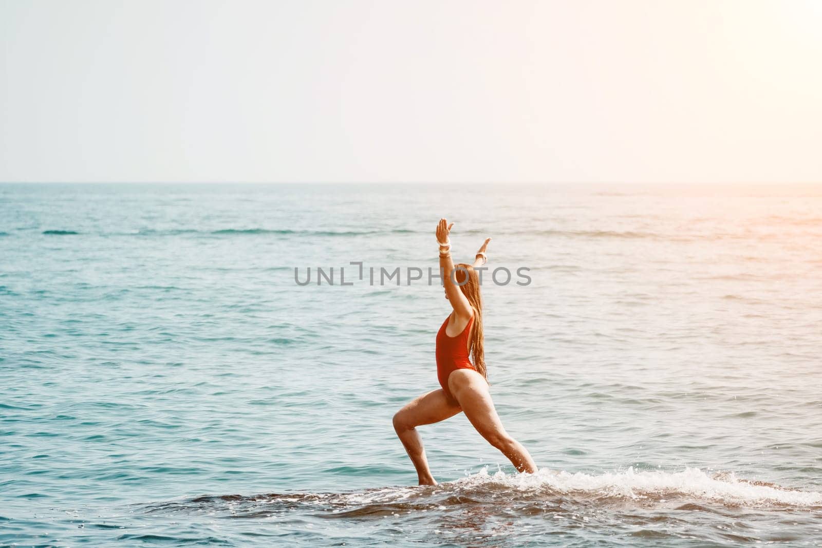 Woman sea yoga. Back view of free calm happy satisfied woman with long hair standing on top rock with yoga position against of sky by the sea. Healthy lifestyle outdoors in nature, fitness concept.