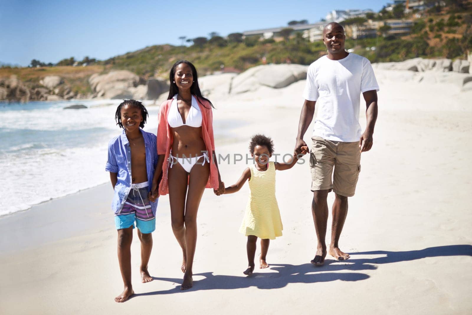 Black family, parents or children and holding hands at beach for adventure, holiday or vacation in summer. African people, face and smile outdoor in nature for experience or bonding and relationship by YuriArcurs