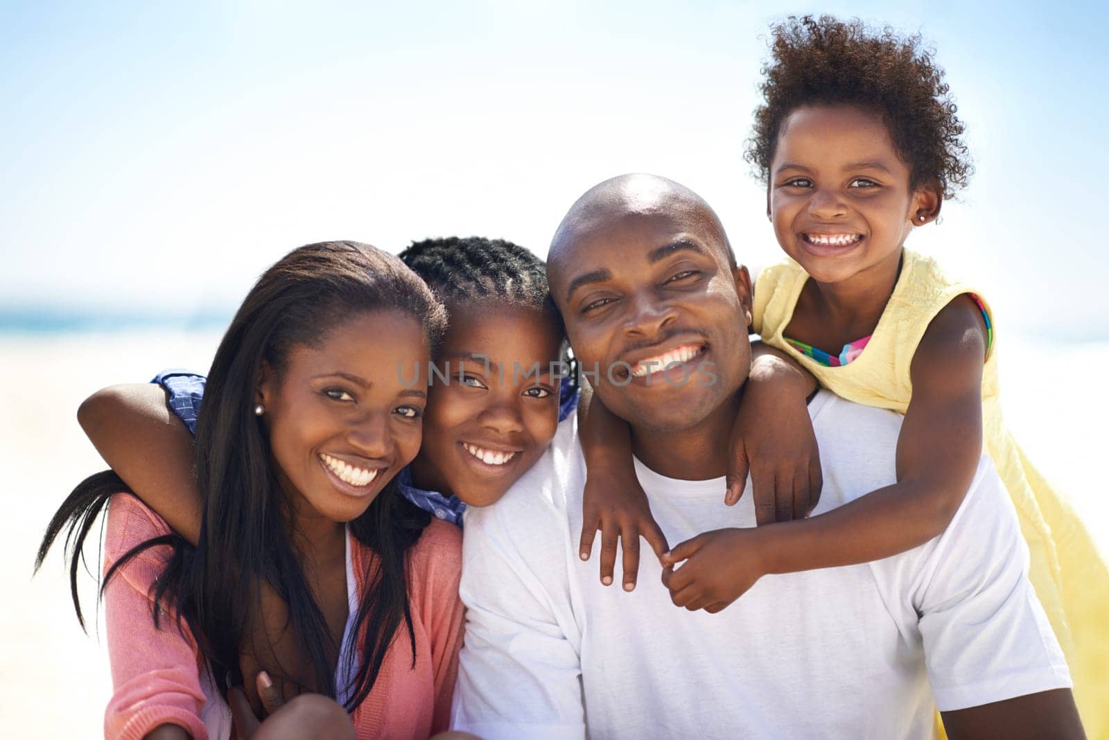 Black family, parents and children with hug at beach for adventure, holiday or vacation in summer. African people, face and smile outdoor in nature for embrace, experience or bonding and relationship.