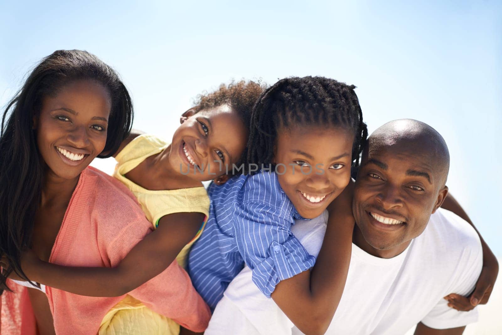 African family, parents and kids with piggyback on beach for adventure, holiday or vacation in summer. Black people, face or smile outdoor in nature for break, playing or bonding with relationship.