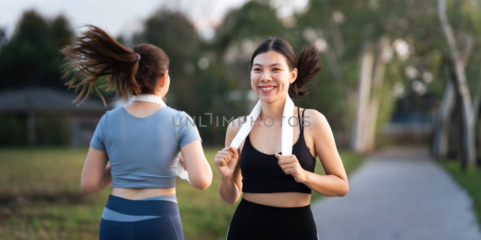 Young smiling sporty woman running in park in the morning. Fitness girl jogging in park by nateemee