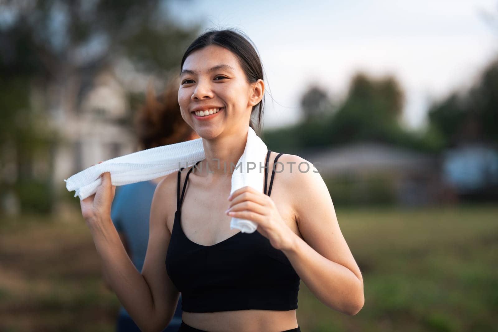 Young smiling sporty woman running in park in the morning. Fitness girl jogging in park.