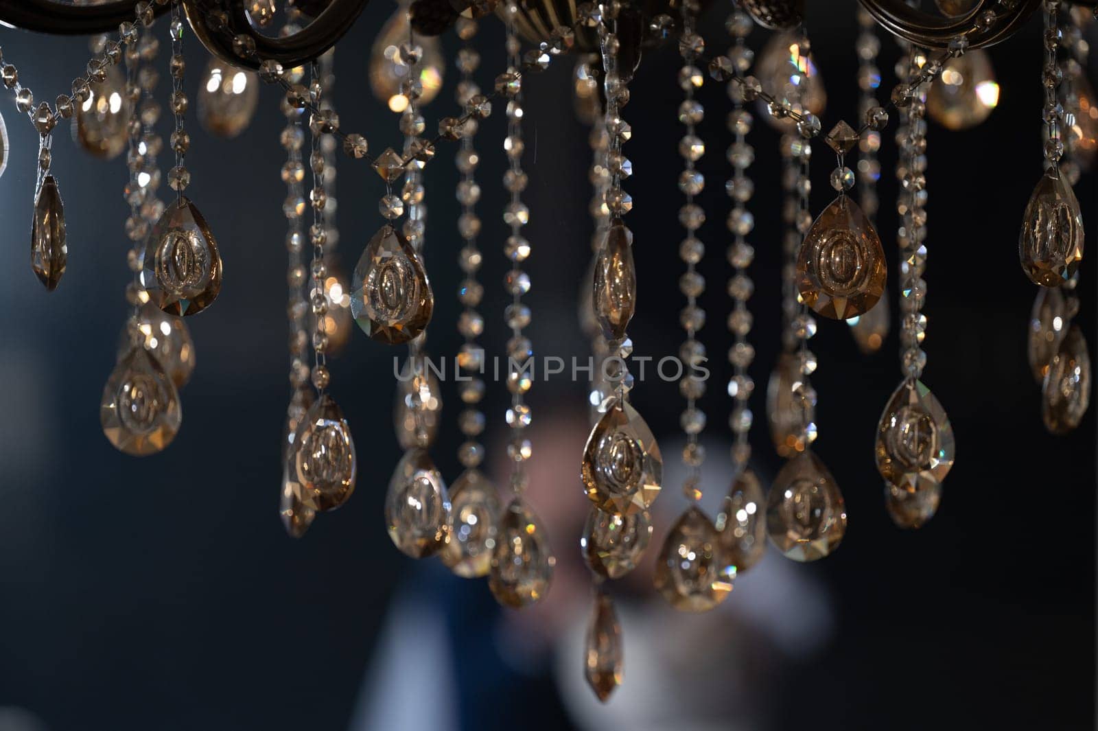 Crystal on a chandelier close-up on a dark background, reflection of light from the crystal.