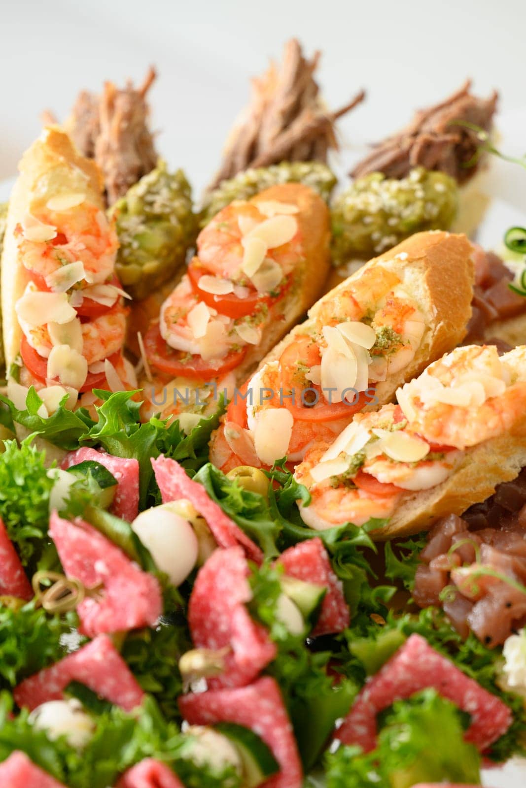 Appetizer with lettuce leaves and canapes with tomato and sausage, an appetizing light snack.