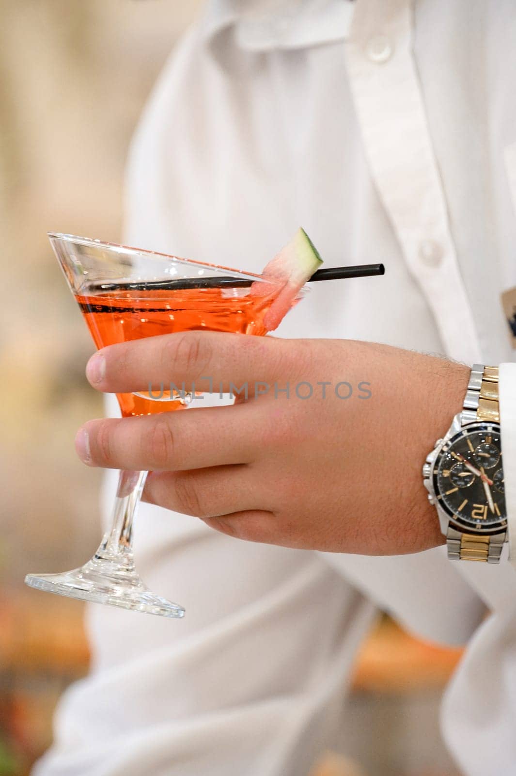 A waiter delivers alcoholic drinks on a tray, close-up.