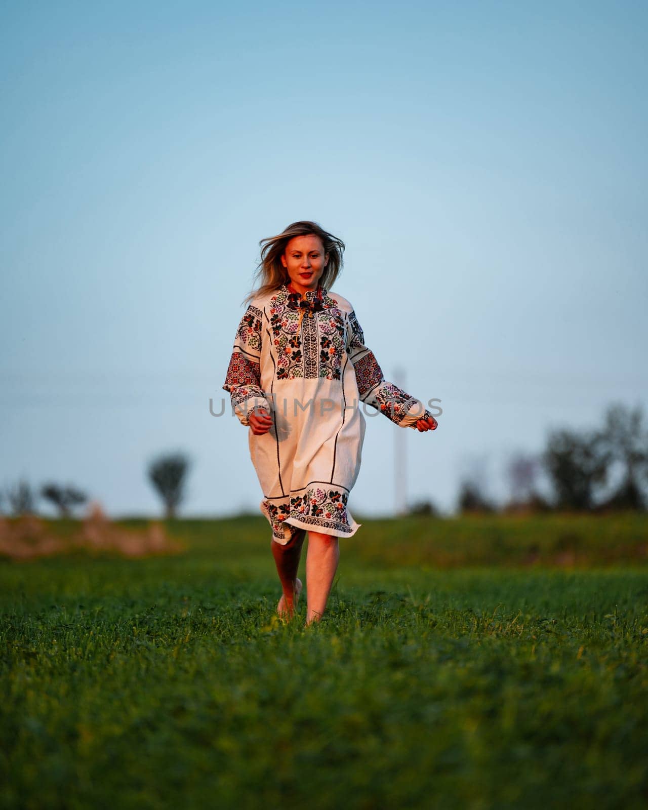 Embroidered and unique petticoat, a girl walks barefoot in the field in an embroidered shirt, Ukrainian clothes and traditions.