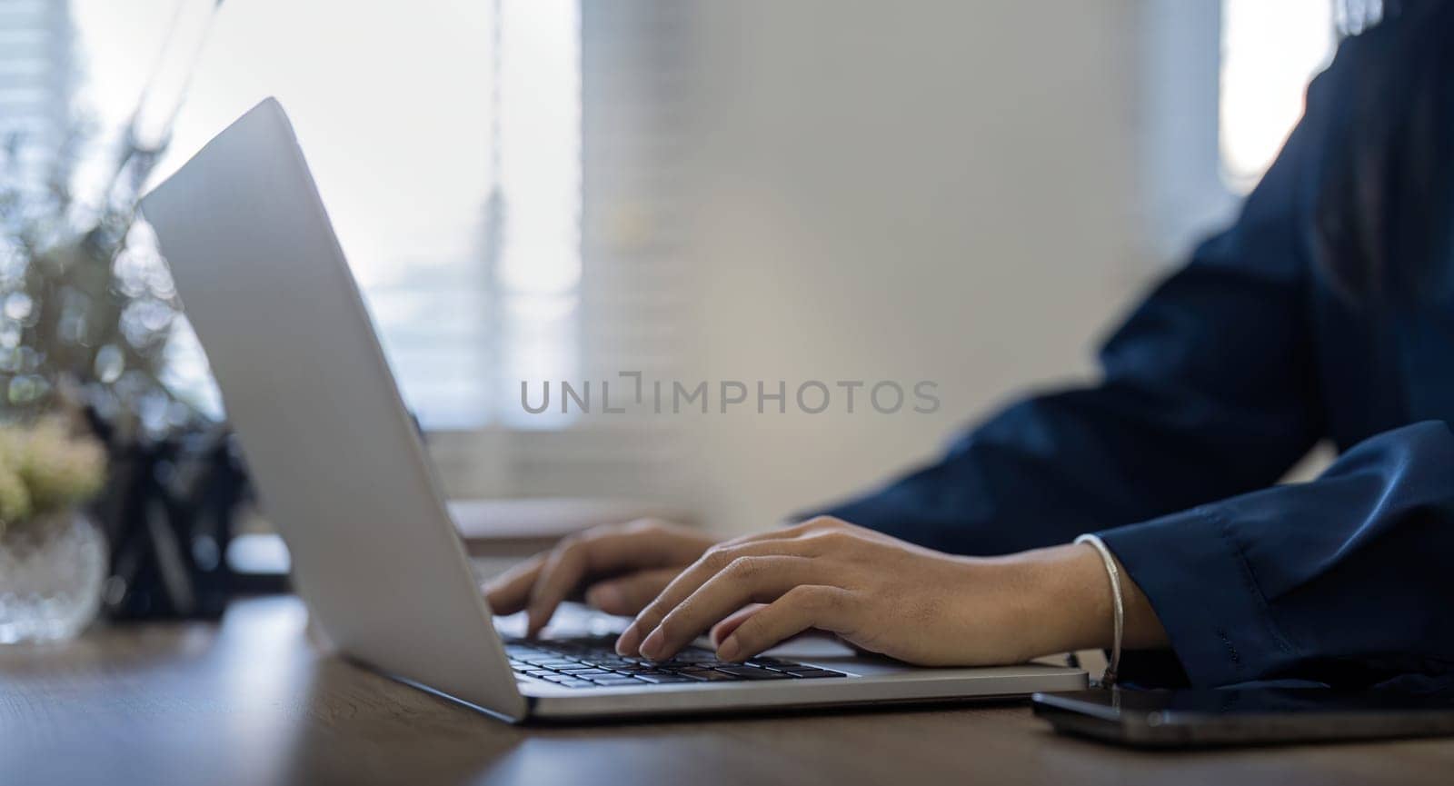 Professional businesswoman working at her home via laptop, young female manager using computer laptop while sitting on desk, work process concept.