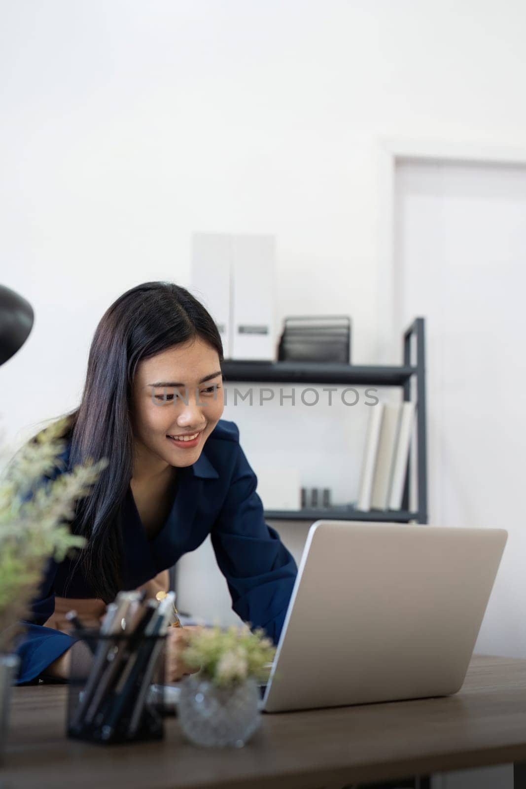 Professional businesswoman working at her home via laptop, young female manager using computer laptop while sitting on desk, work process concept by nateemee