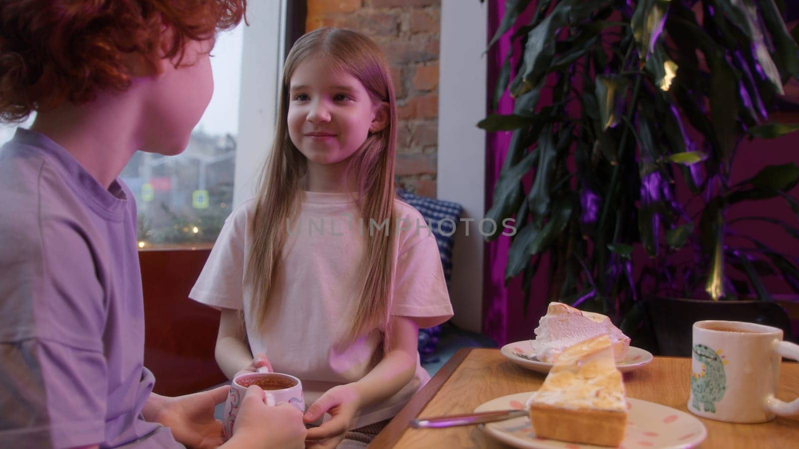 Cute couple of kids in cafe. Stock footage. Beautiful couple of kids on date in cafe. First love of children on date in cafe by Mediawhalestock