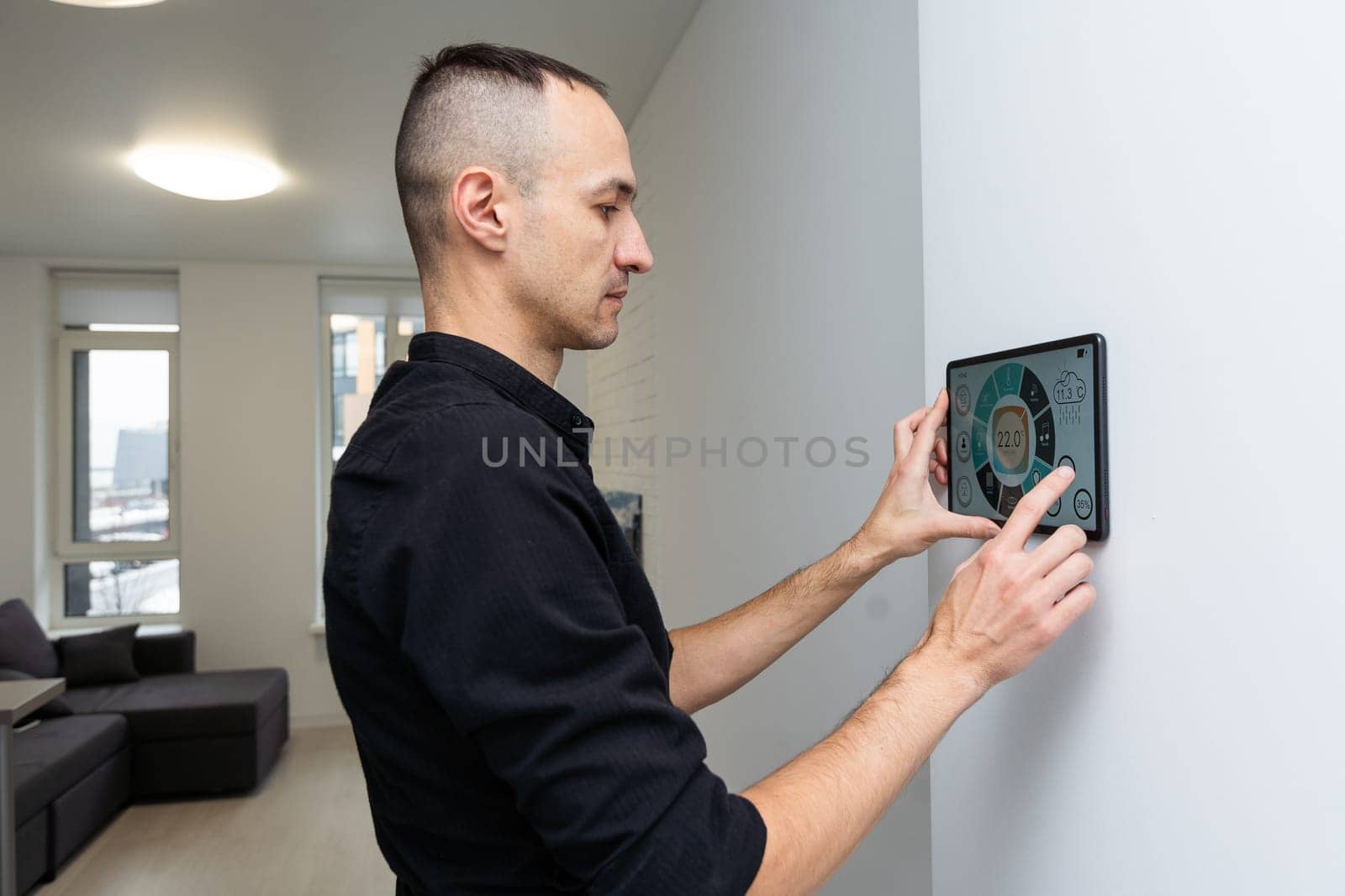 Worker with tablet computer checking alarm system indoors by Andelov13