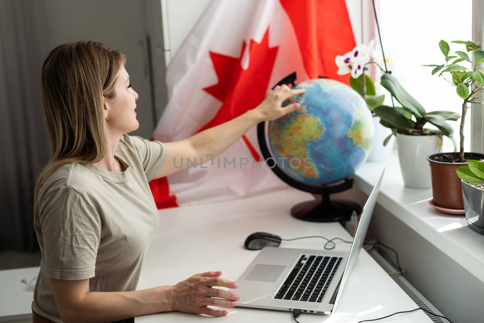 beautiful smiling woman covered in canadian flag looking at camera isolated on white. High quality photo