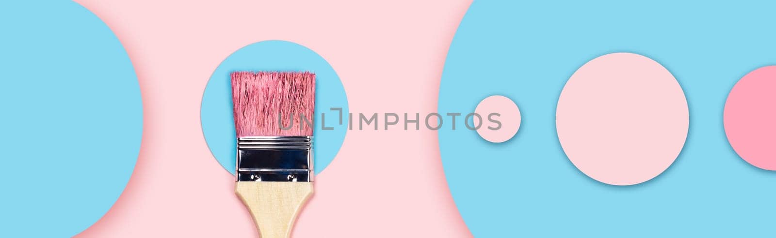 Web banner on a renovation topic. One paintbrush on a pink and blue background with colored paper circles.