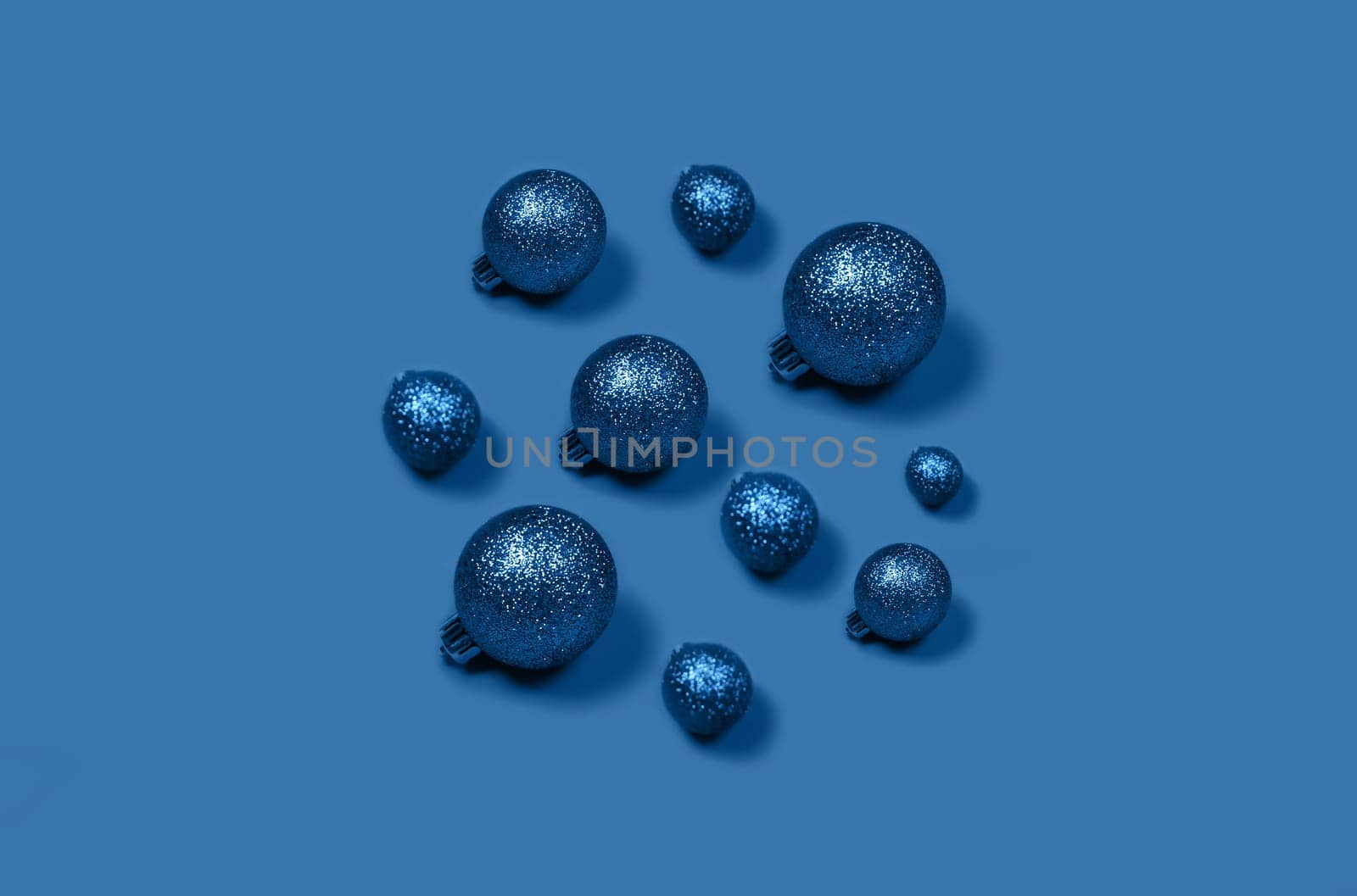 Volume Christmas composition of blue Christmas balls laid out in the form of circle on bright background.