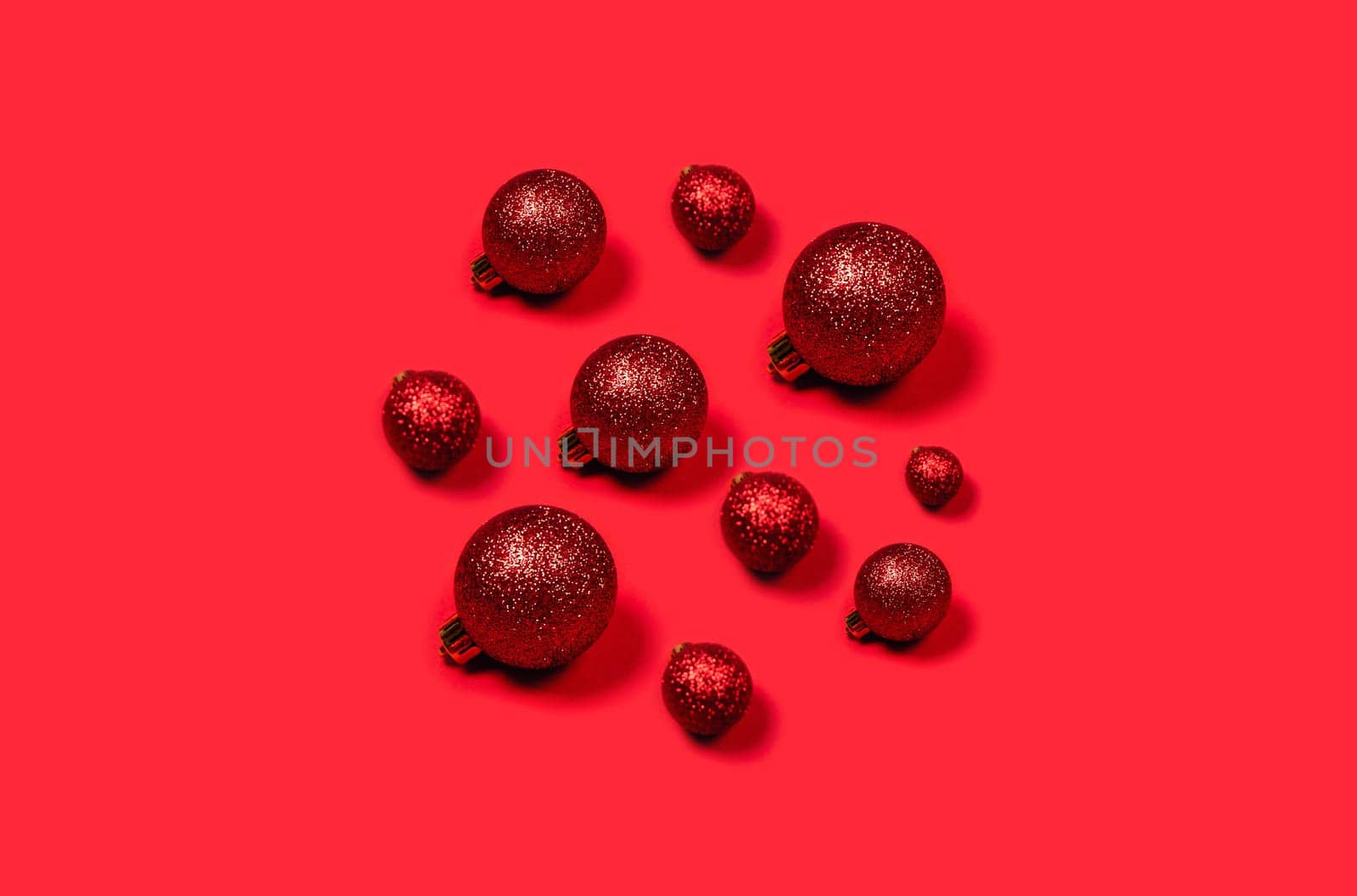 Red Christmas balls laid out in the form of circle on bright background.